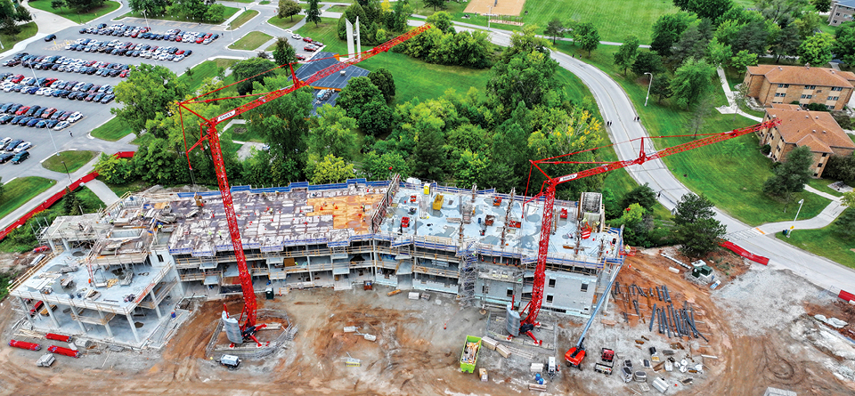 Immel Construction uses two Potain Igo T 99 self-erecting tower cranes to lift materials as it constructs a new residence hall at the University of Wisconsin-Green Bay.