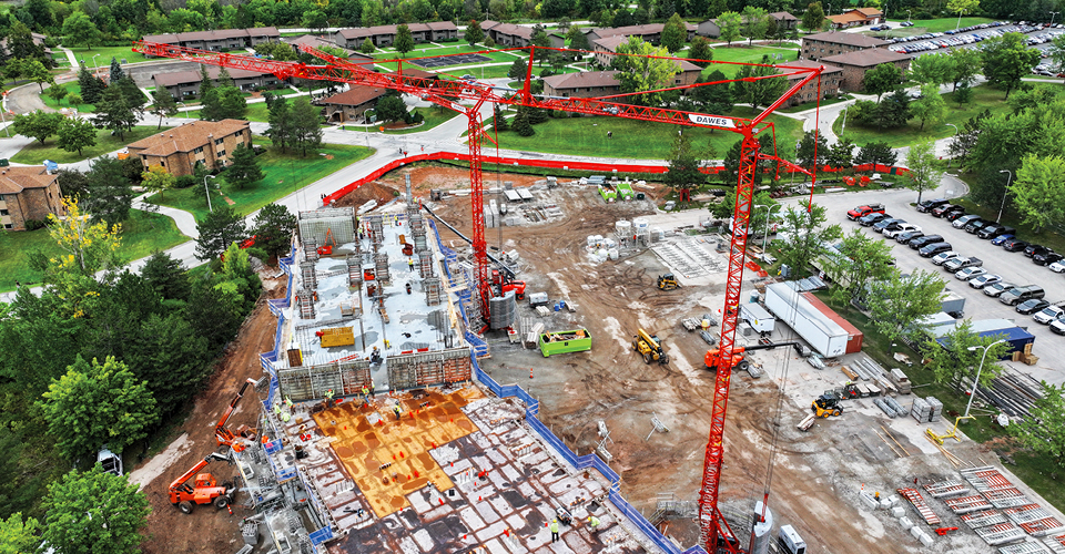 Immel Construction utilizes two Potain Igo T 99 self-erecting tower cranes that each have a 6-t lifting capacity and a 157-ft reach for the structural building phase of a residence hall at the University of Wisconsin-Green Bay.