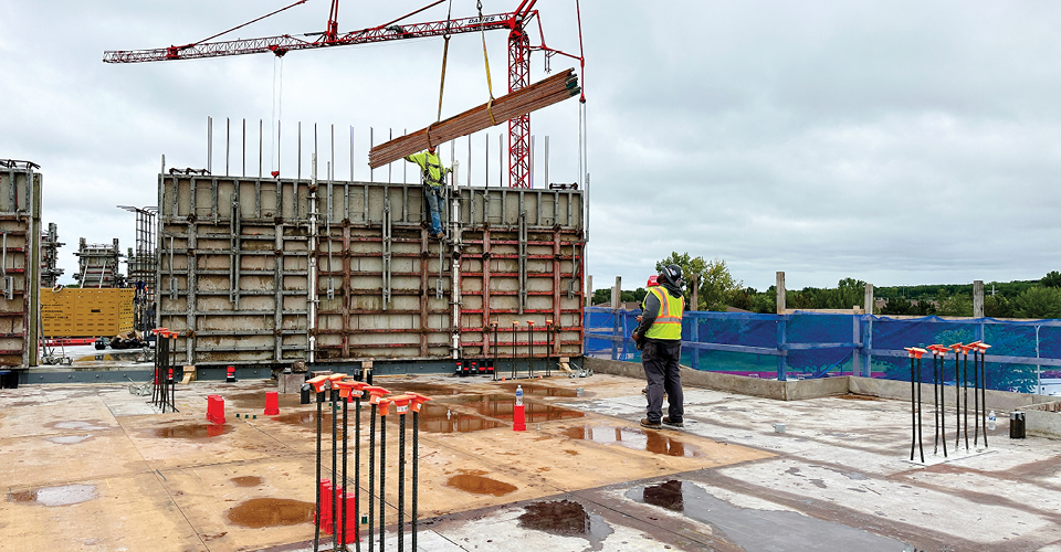 Operator David Chavanes uses a remote control to place materials with a Potain Igo T 99 self-erecting tower crane.