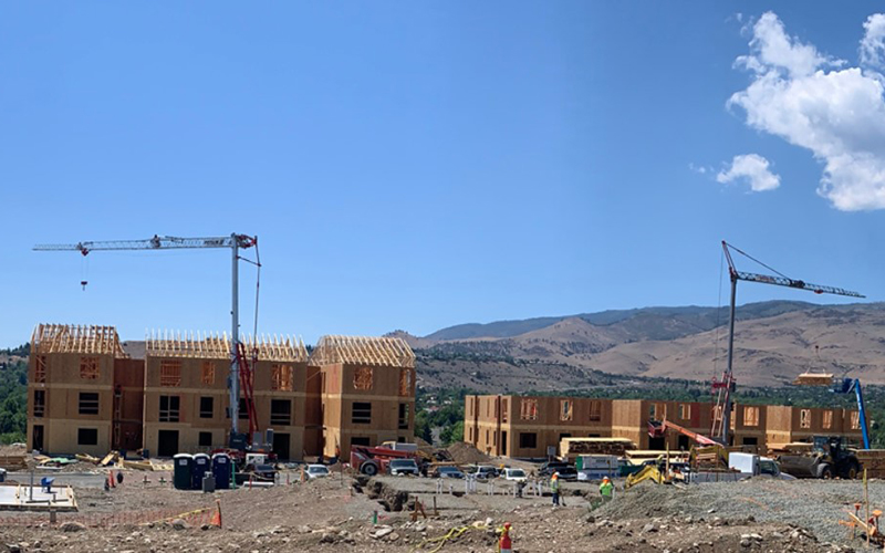 Potain Hup M self-erecting crane repositioning autonomously between lift points on an active multi-phase construction site