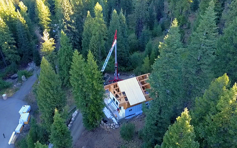Single operator erecting Potain Igo M self-erecting tower crane on residential construction site using remote control